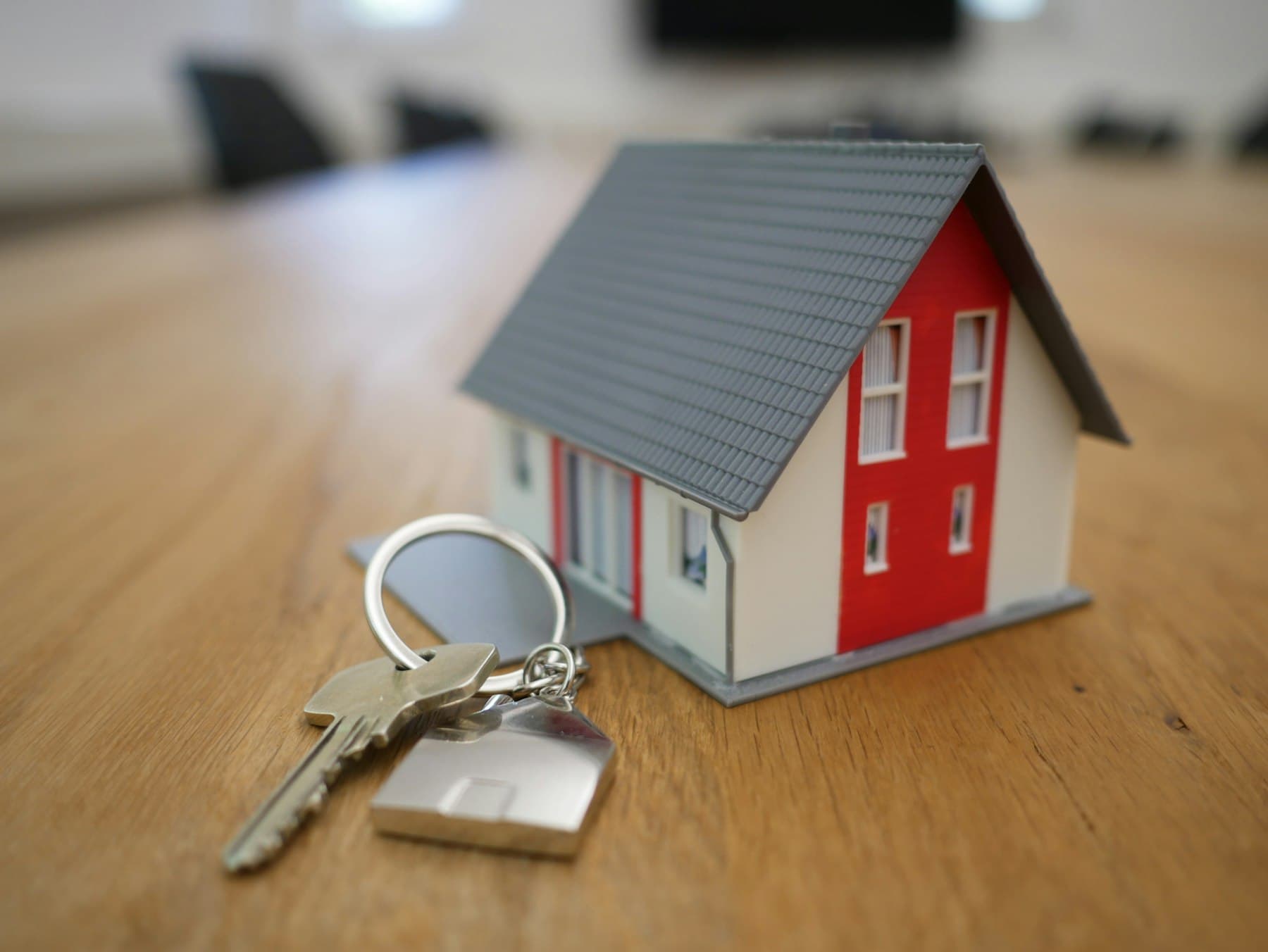 Maquette de maison et trousseau de clés posés sur un bureau